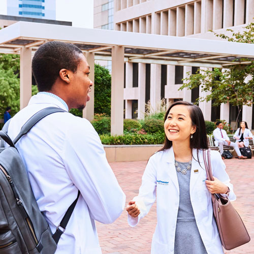 two medical students talking and smiling outside