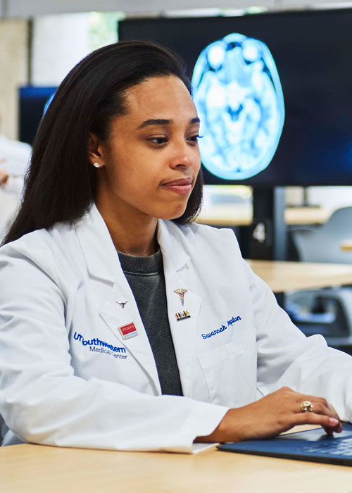 medical student typing on a laptop