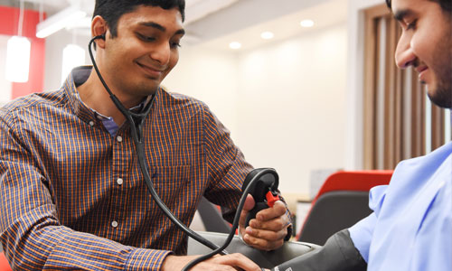 medical student taking another students blood pressure